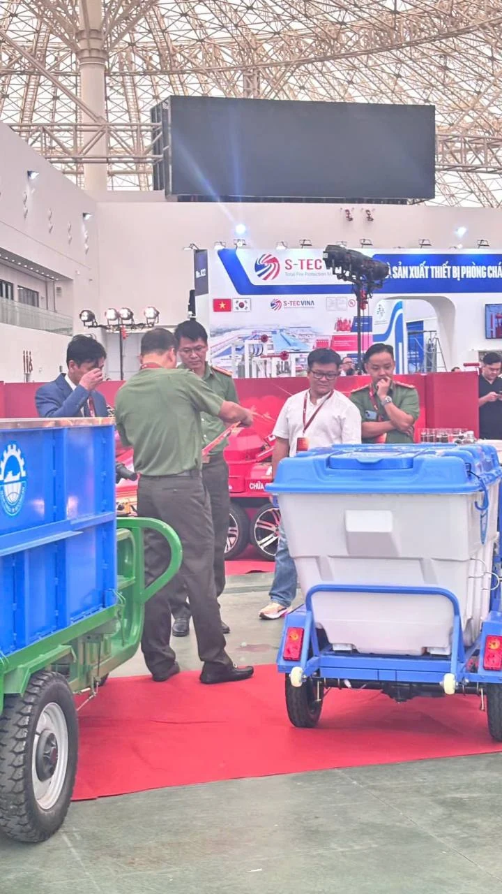 Xe điện chở thùng có nắp xanh và xe thùng mở tại khu trưng bày; ảnh do MINGMA cung cấp.